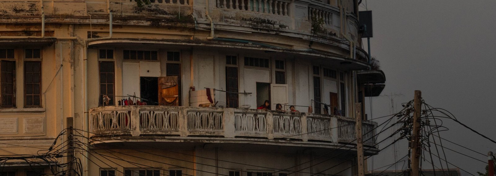 Stary okrągły budynek nad rzeką Chao Phraya w Bangkoku podczas zachodu słońca, widok z łodzi na rzece