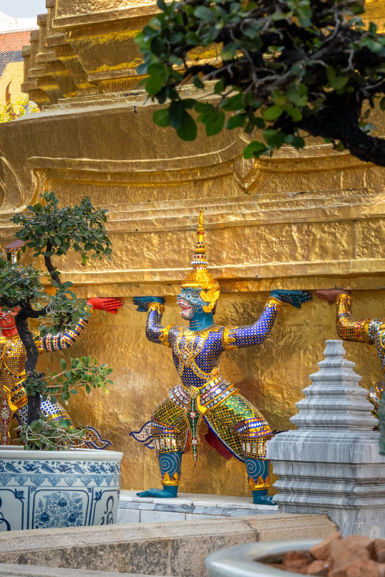 Strażniczy posąg Yaksha w Wielkim Pałacu Królewskim w Bangkoku, stojący w pobliżu modelu Angkor Wat, tradycyjny demon-strażnik tajskiej architektury sakralnej.