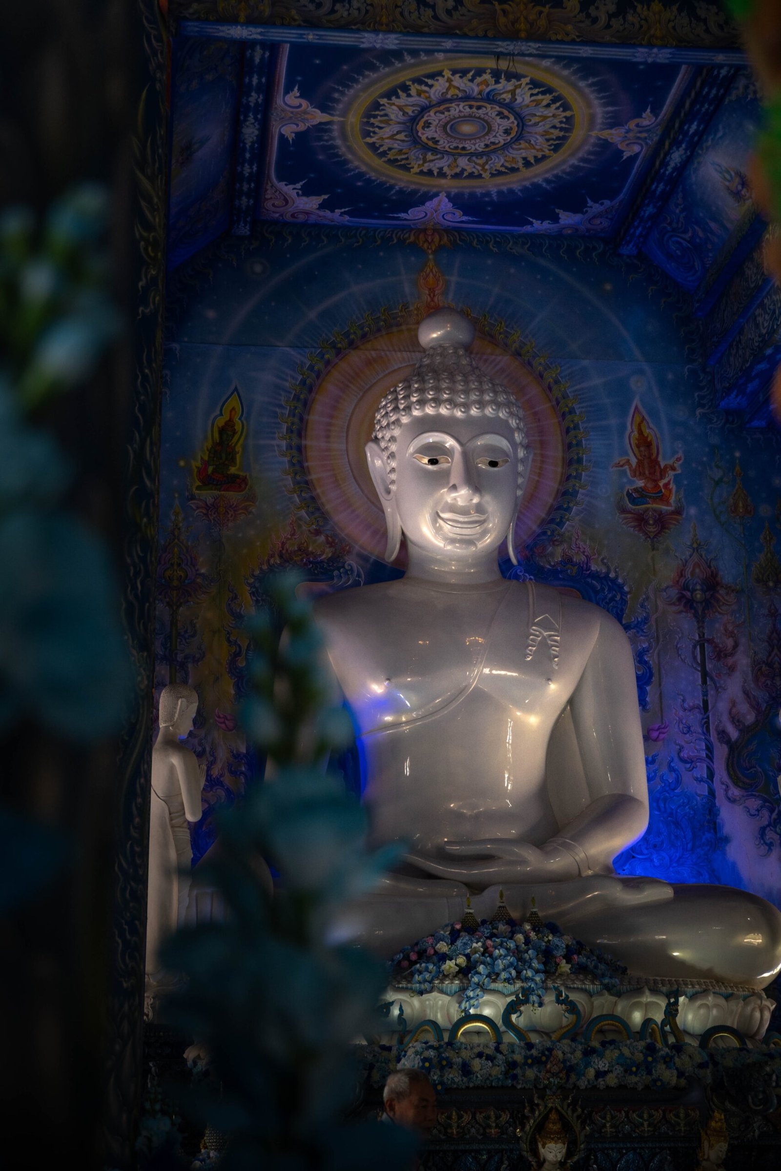 Wnętrze Niebieskiej Świątyni Wat Rong Suea Ten w Chiang Rai – wielki biały posąg Buddy i błękitne freski