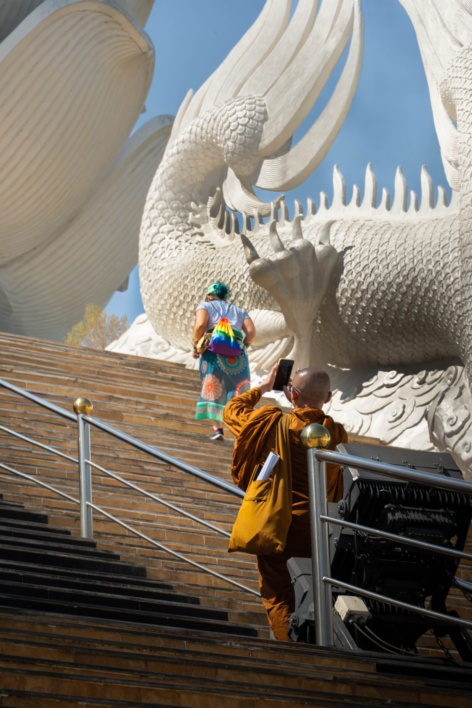 Buddyjski mnich na tle wielkiego białego smoka w świątyni Wat Huay Pla Kang, Chiang Rai – kultura Tajlandii
