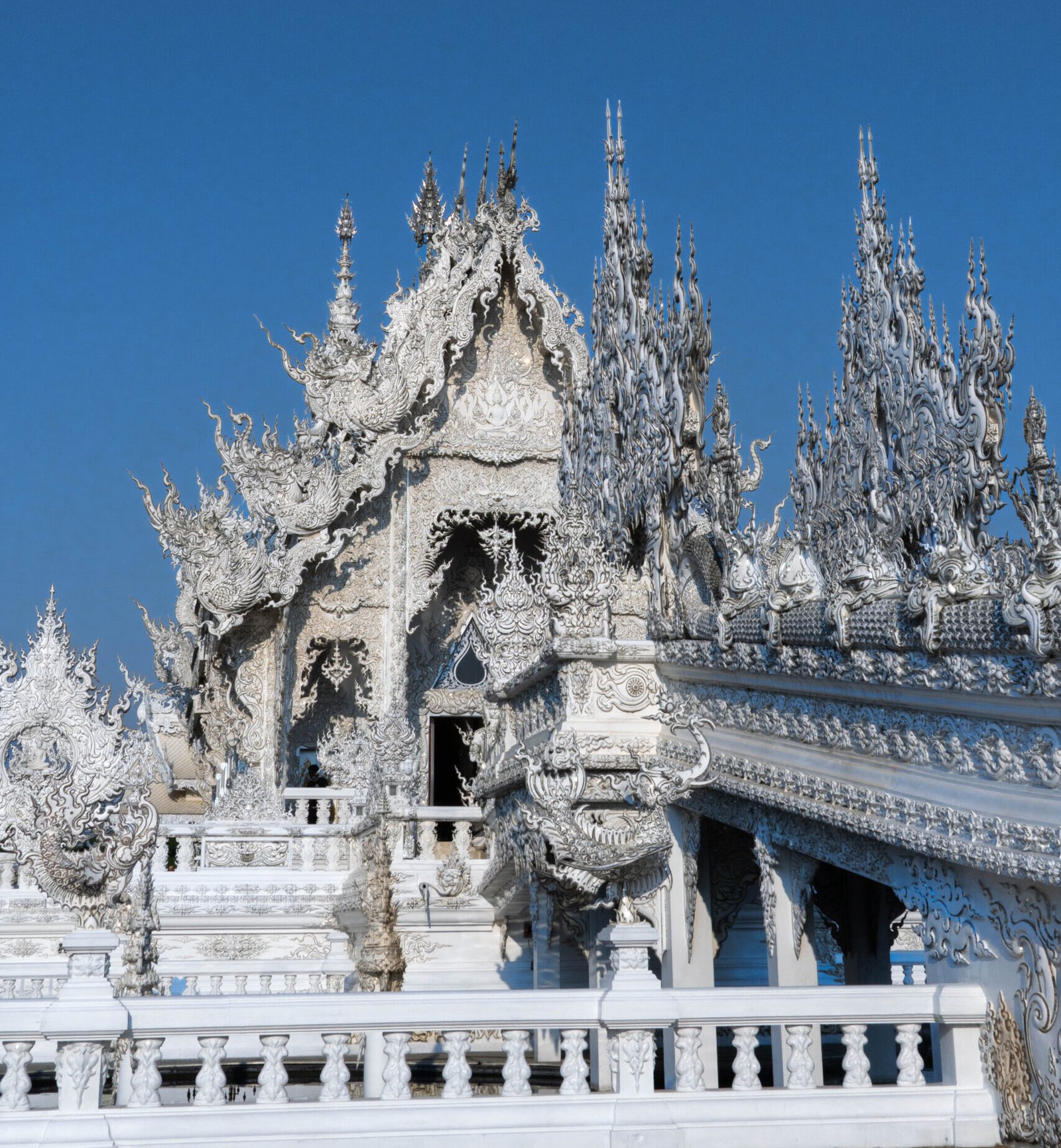 Zwiedzanie Chiang Rai: most nad piekłem prowadzący do głównej budowli Białej Świątyni, znana atrakcja północnej Tajlandii.