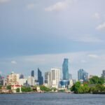 Beautiful view of Bangkok skyline with skyscrapers and river on a sunny day.